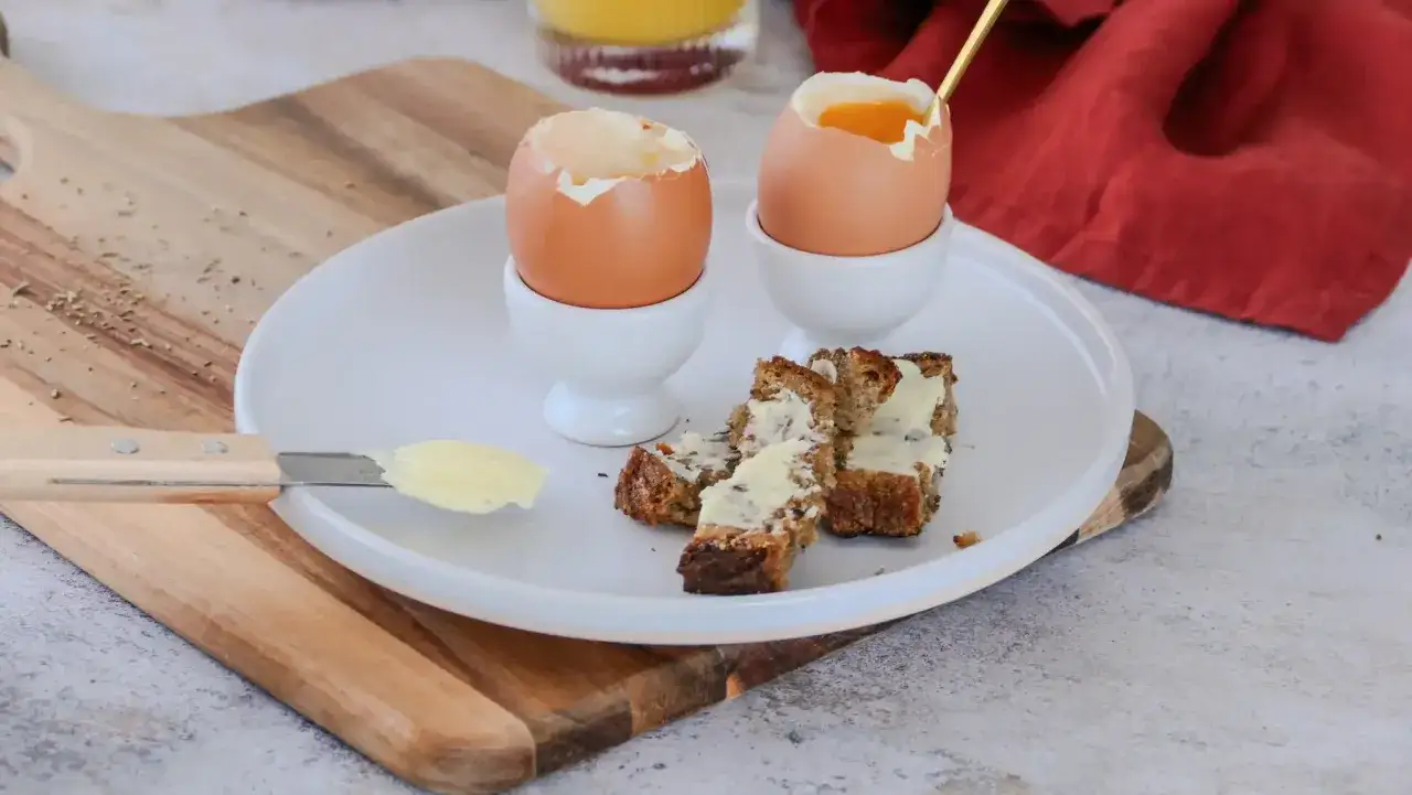 Deux œufs à la coque parfaits, prêts à être dégustés avec du pain beurré. Le temps idéal pour un petit-déjeuner savoureux.