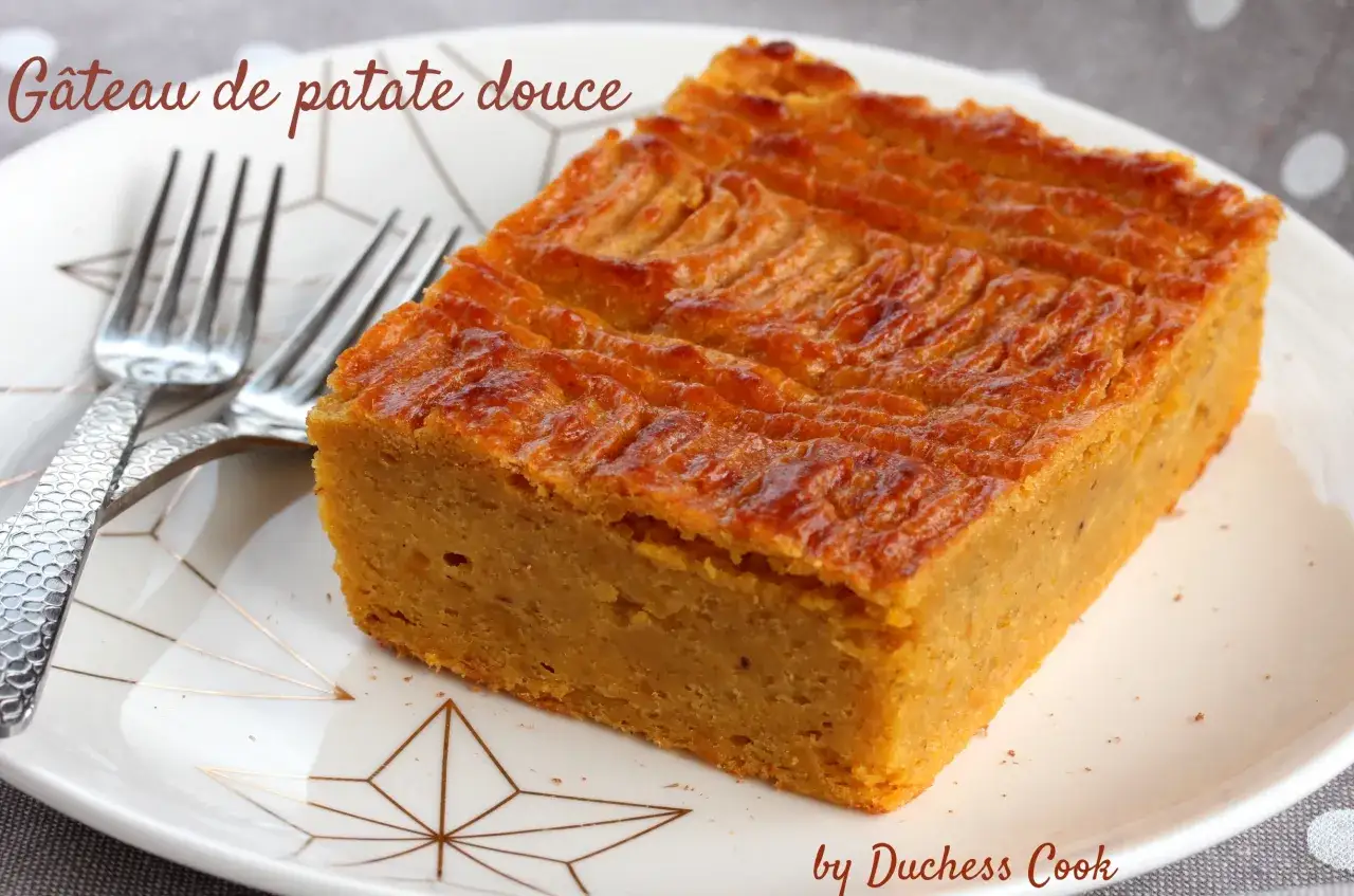 Un délicieux gâteau de patate douce, doré et moelleux, servi sur une assiette ornée de motifs géométriques, avec deux fourchettes argentées.