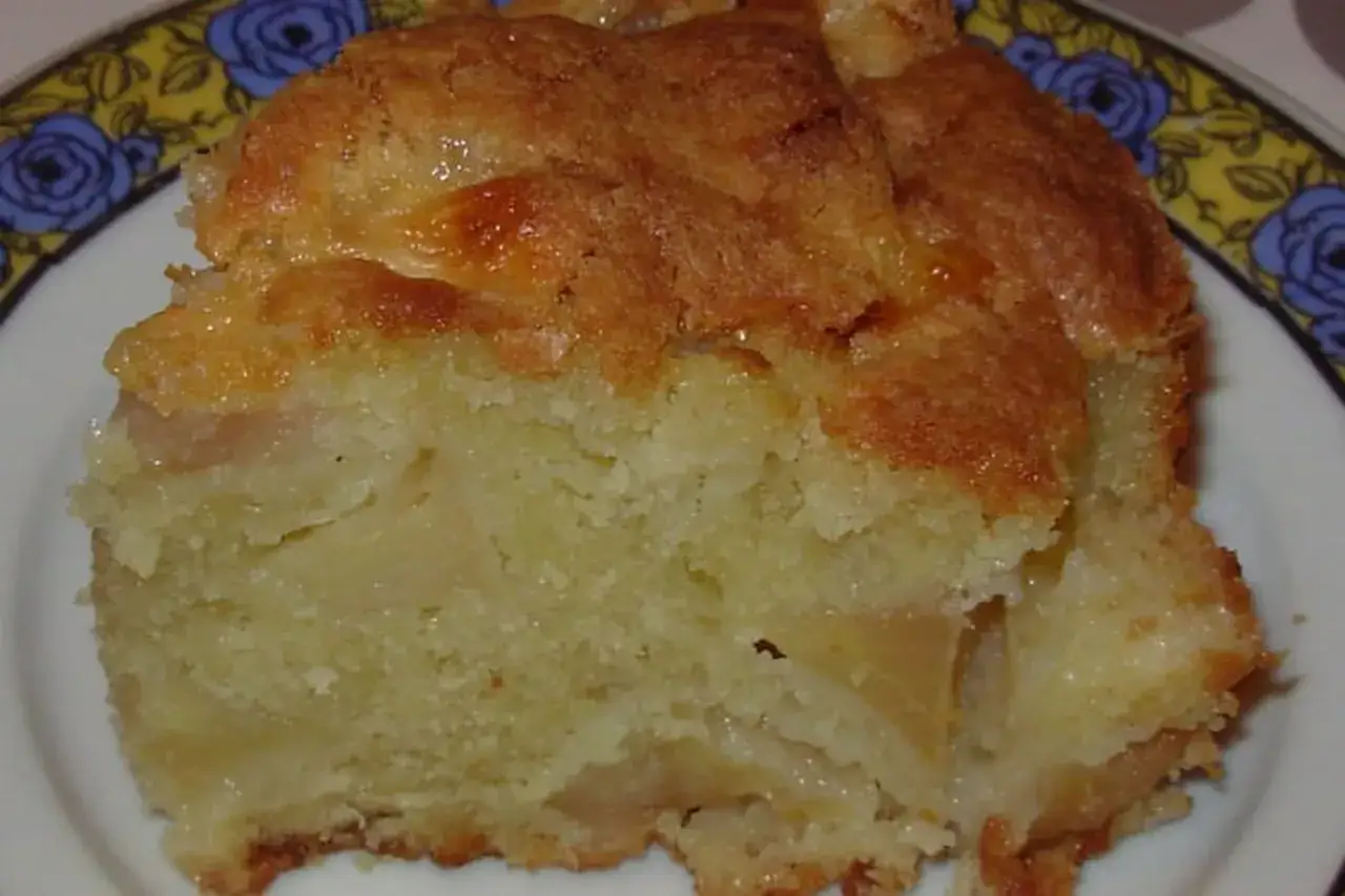 Une part de gâteau moelleux aux pommes, avec une croûte dorée et caramélisée. Un délice invisible aux pommes qui fond en bouche.