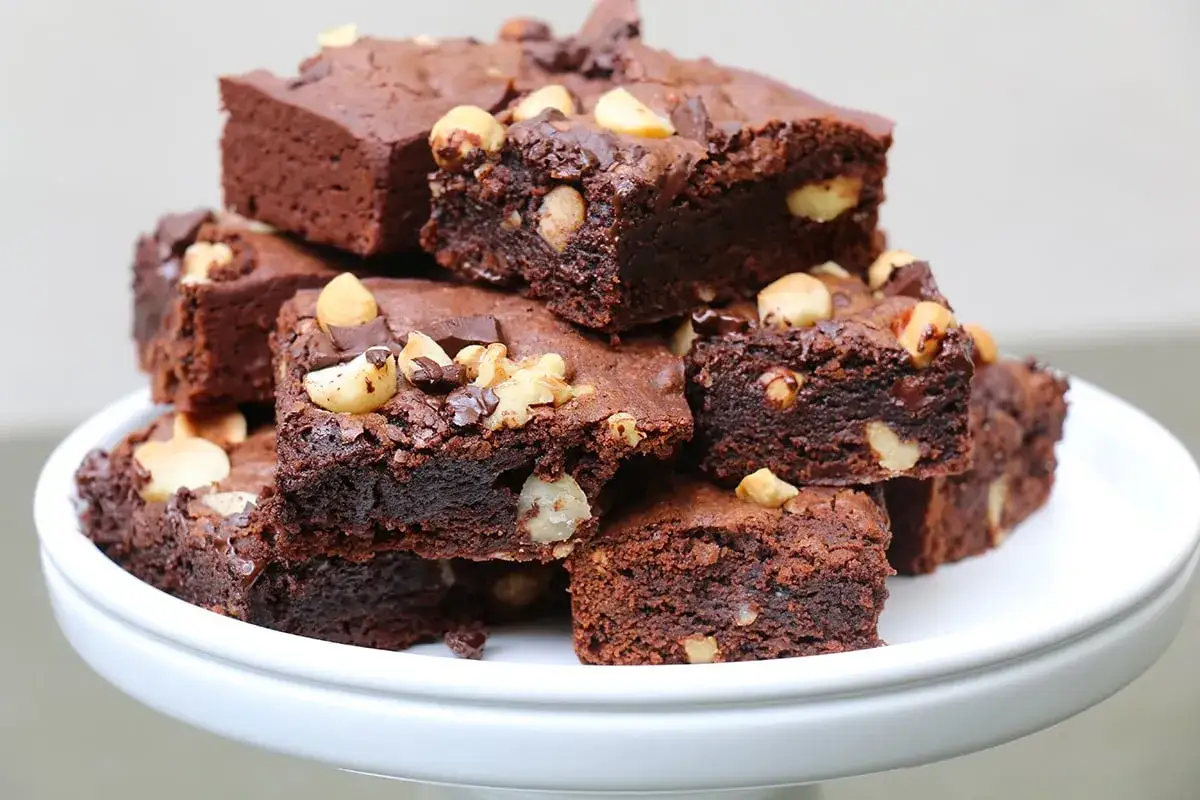 Pile de d&eacute;licieux brownies au chocolat, parfaits pour une recette facile. Garnis de noix et de p&eacute;pites de chocolat.
