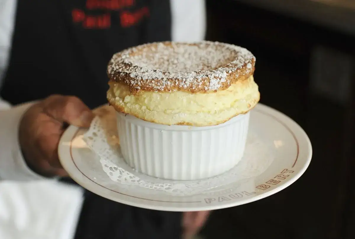 Un soufflé Grand Marnier, aérien et saupoudré de sucre glace, prêt à être dégusté. Une création digne de Cyril Lignac.