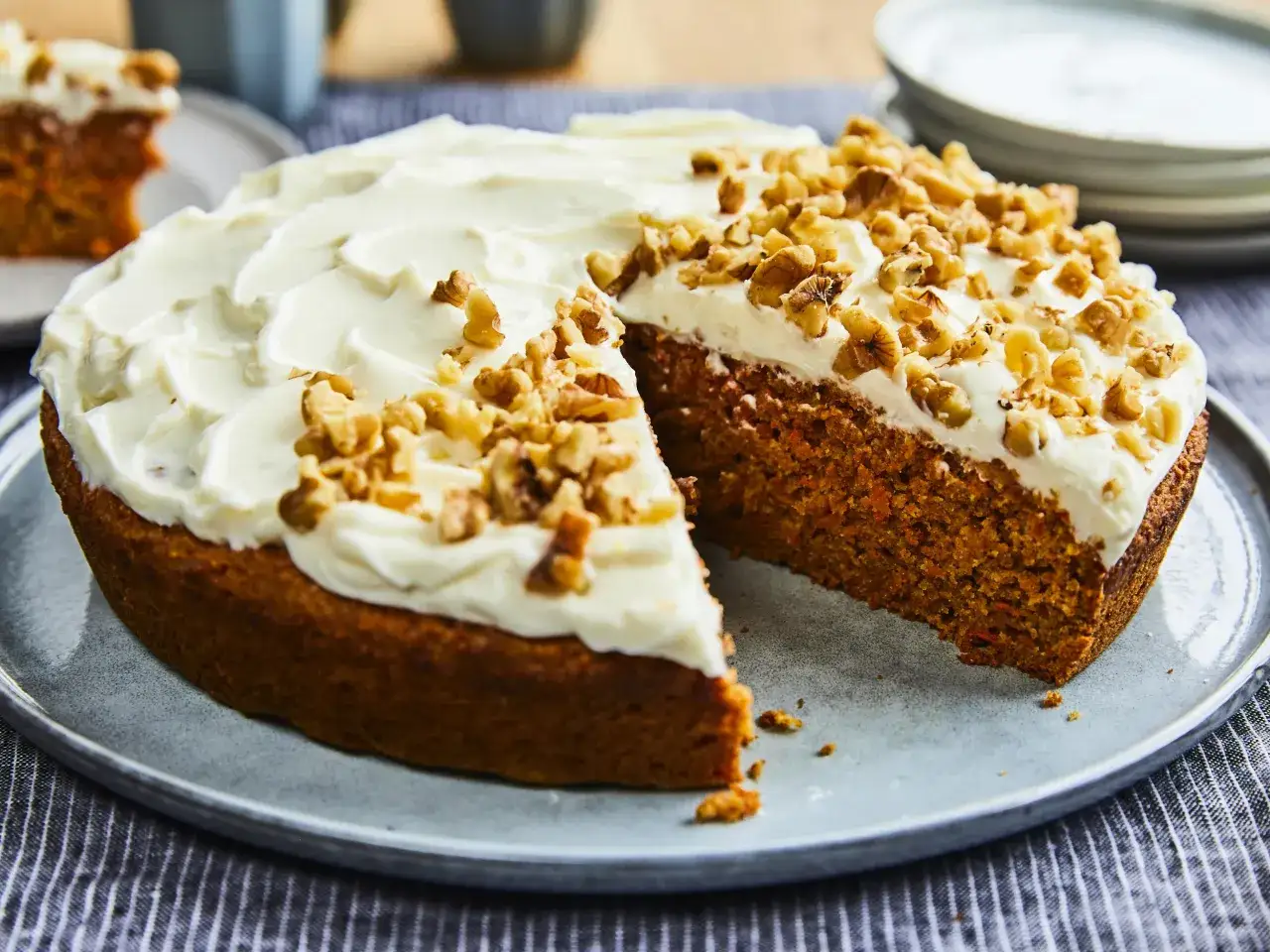 Un délicieux carotte cake, généreusement glacé et parsemé de noix, prêt à être dégusté. Une recette parfaite pour le goûter.