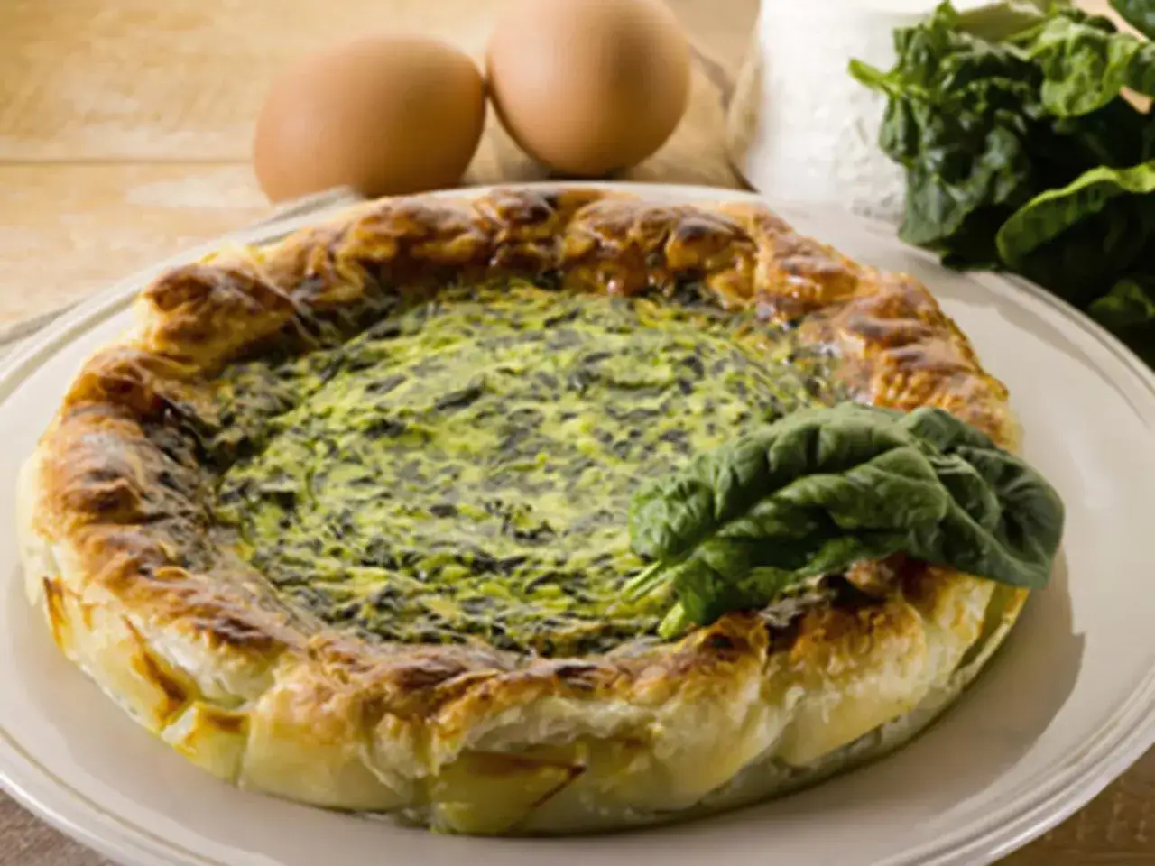 Tarte &eacute;pinard ch&egrave;vre dor&eacute;e, garnie de feuilles fra&icirc;ches. Des &oelig;ufs et du fromage &agrave; c&ocirc;t&eacute; sugg&egrave;rent les ingr&eacute;dients de cette d&eacute;licieuse tarte.