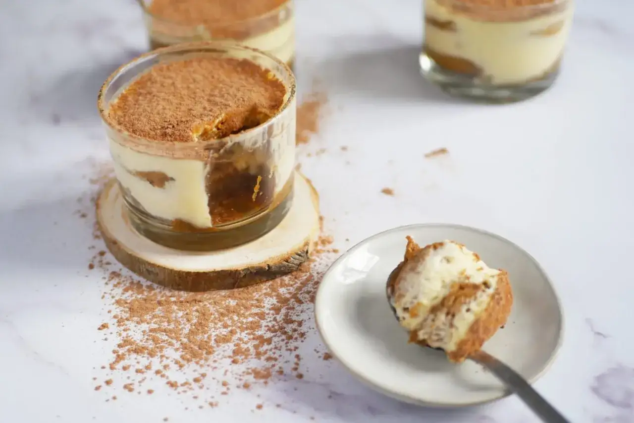 D&eacute;licieux tiramisu individuel, un dessert rapide sans cuisson, saupoudr&eacute; de cacao. Une cuill&egrave;re en est pr&ecirc;te &agrave; &ecirc;tre d&eacute;gust&eacute;e.
