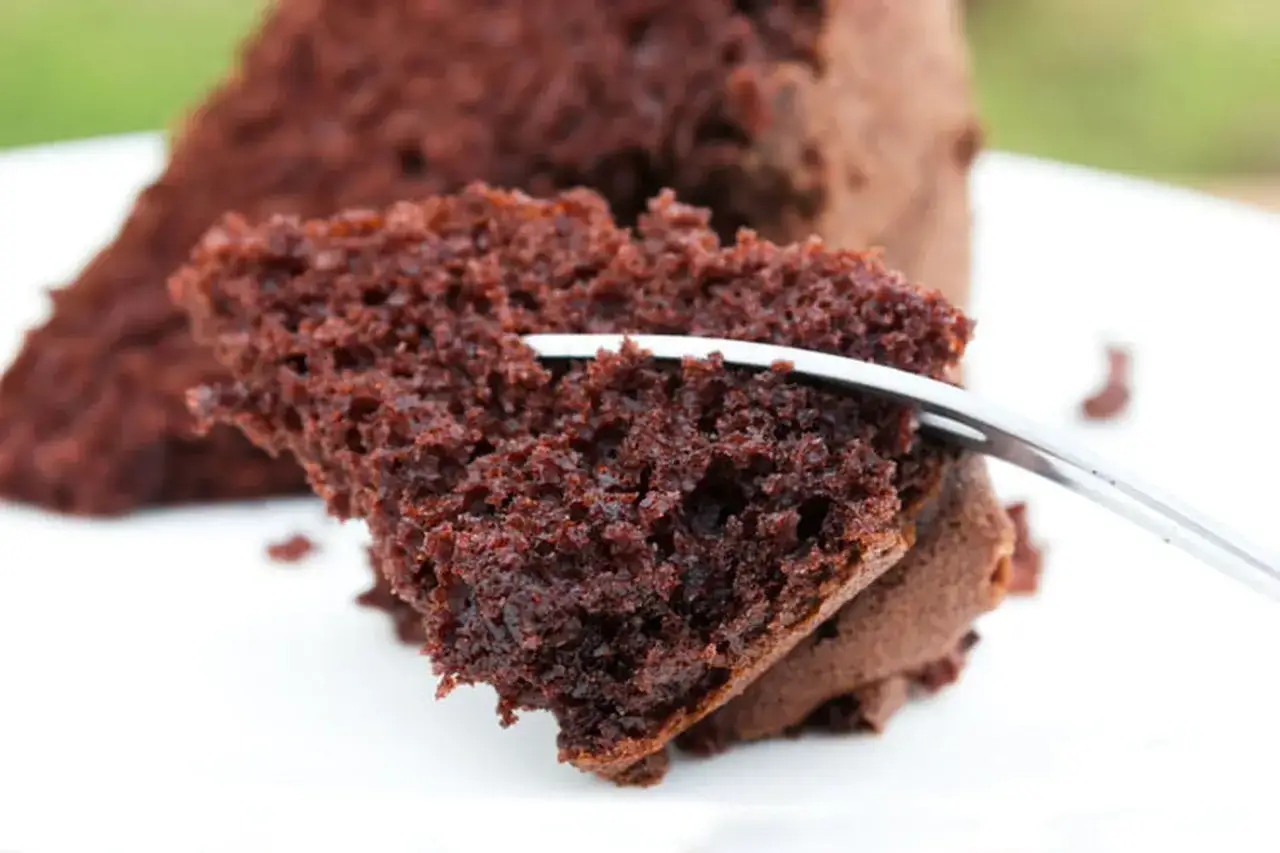 Une part de moelleux gâteau au chocolat, prête à être dégustée. La texture aérée invite à découvrir cette recette gourmande.