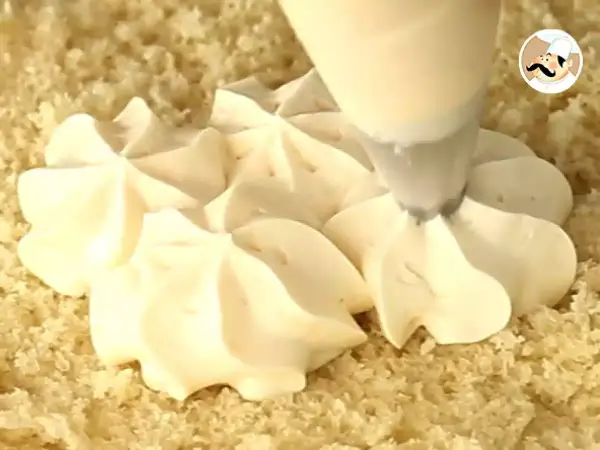 Application d'une crème pâtissière pour tarte à la poche à douille, créant de jolies rosaces sur une base de gâteau.