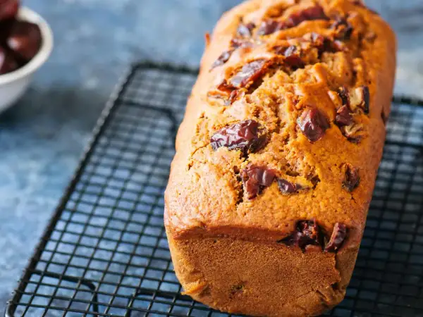 Un délicieux gâteau moelleux aux dattes, tout juste sorti du four et refroidissant sur une grille.
