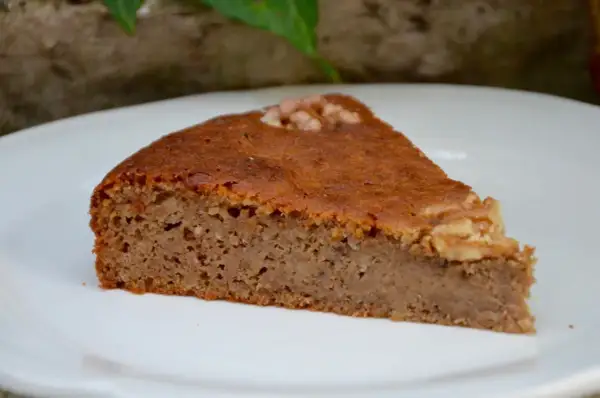 Tranche de gâteau aux noix moelleux, garnie d'une noix entière. Parfait pour une recette facile et gourmande.