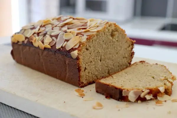 Un délicieux gâteau aux amandes effilées, coupé en part, promettant le meilleur gâteau aux amandes.