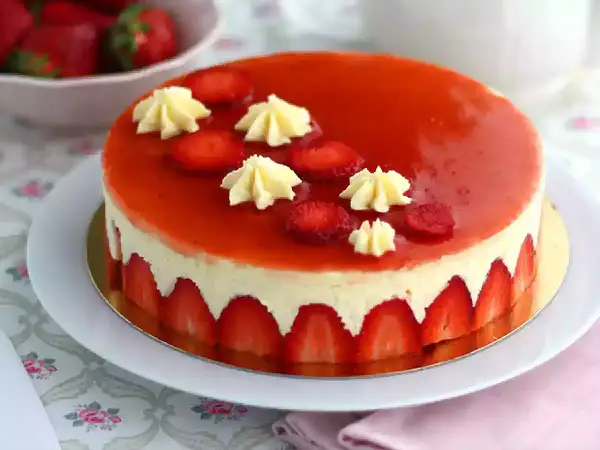 Un magnifique fraisier, parfait pour une recette gourmande. La crème onctueuse est bordée de fraises fraîches, le tout nappé d'un glaçage rouge éclatant.