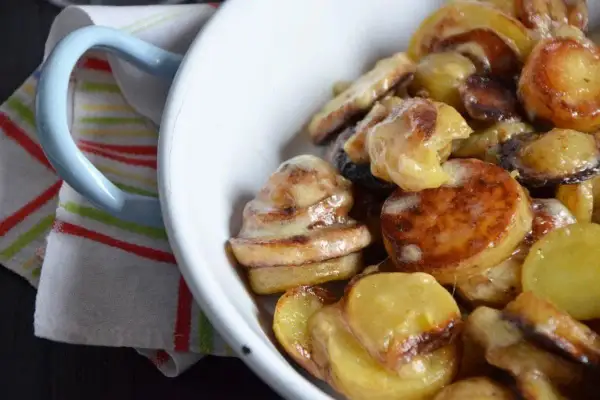 Un plat de truffade de l'Aubrac, pommes de terre fondantes et crémeuses, servi dans un bol blanc.