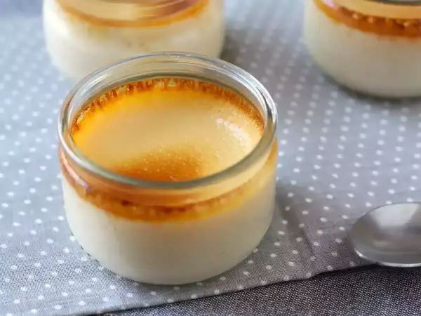 Crème aux œufs grand-mère dans des pots en verre, avec une croûte caramélisée dorée. Un délice réconfortant.