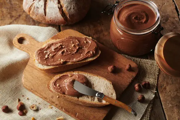 Tartines de pain de campagne généreusement garnies de pâte à tartiner aux noisettes, inspirée par la recette de Cyril Lignac. Un délice gourmand !