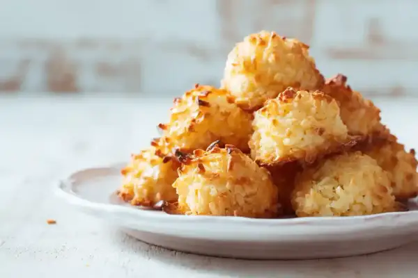 Pile de rochers coco dorés et croustillants sur une assiette blanche. Un délice à croquer !