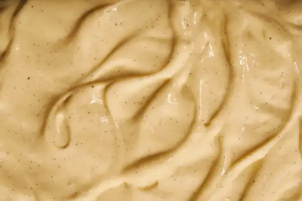 Texture onctueuse de crème pâtissière à la vanille, parsemée de petits points noirs de vanille.